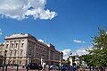 Grand city building below beautiful blue sky and clouds